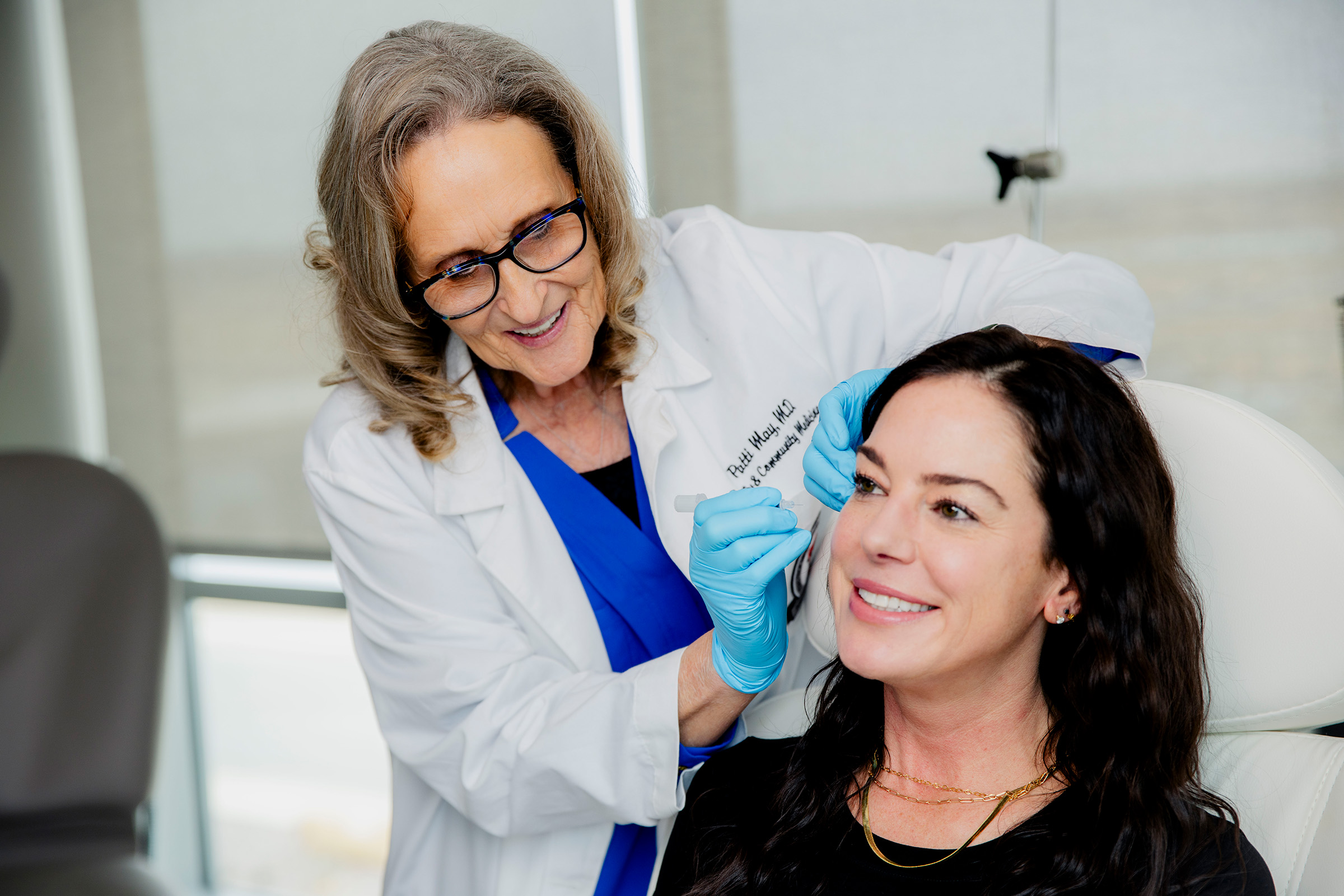 Doctor looking closely at patient's face to administer Botox injections.