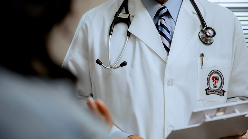 Provider holding clipboard in front of patient