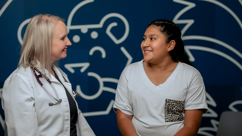 pediatric doctor and patient smiling at each other