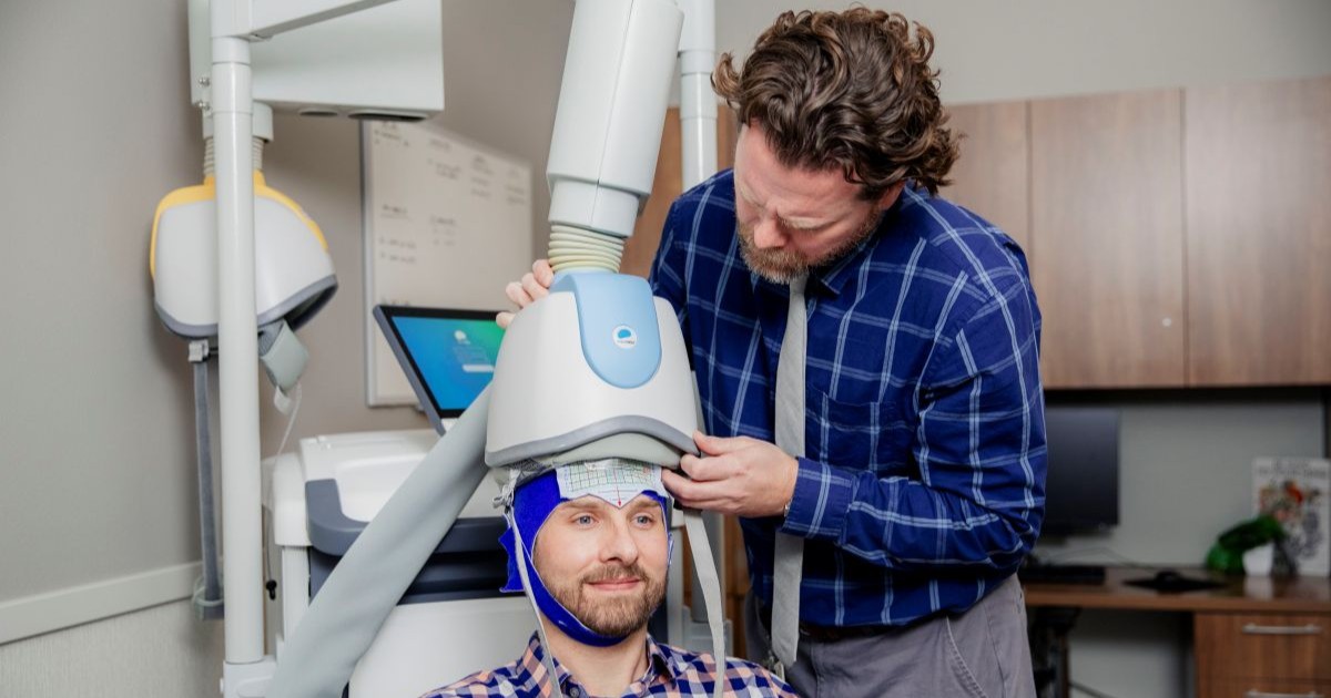 Physician uses TMS machine on patient