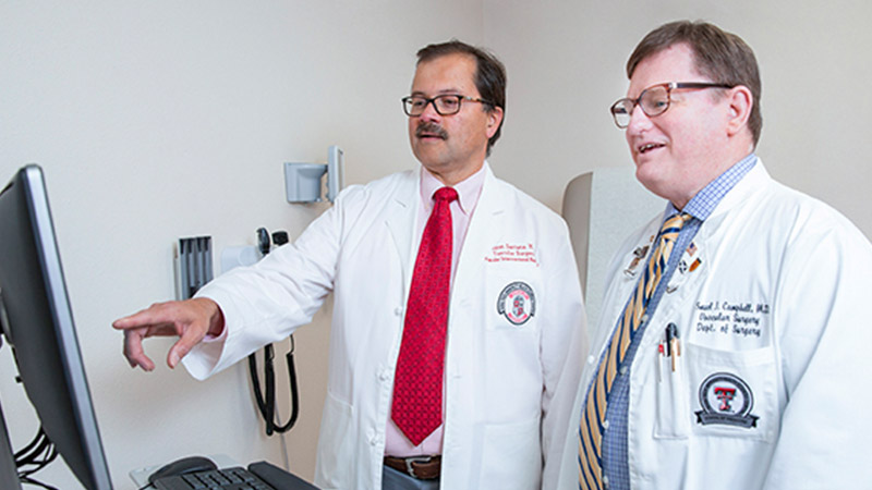 Provider standing and pointing at screen with another provider.