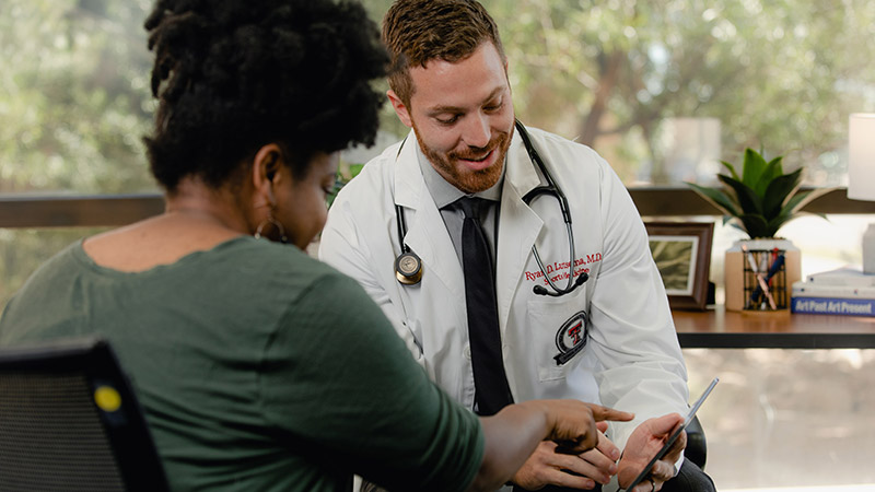 Provider help patient sitting down looking at iPad
