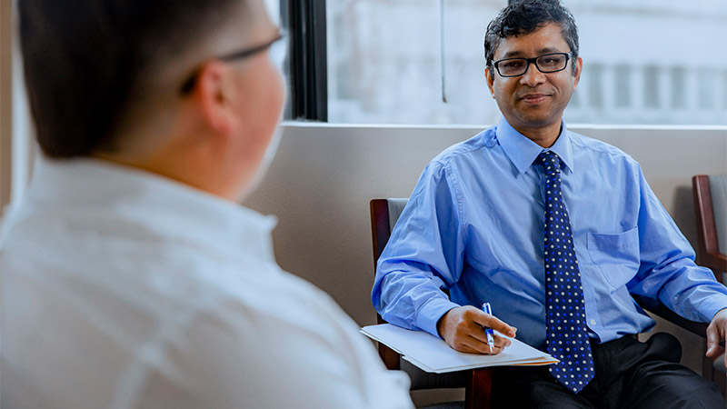 Physician listening and taking notes with a patient